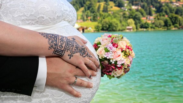 Hochzeitsbild mit Babybauch und Brautstraus