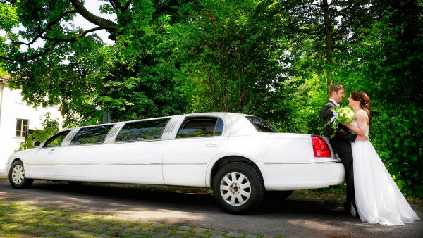 Hochzeitsbild: Brautpaar mit Stretchlimousine